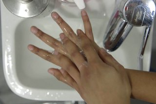 image of cleaning between the fingers over the sink