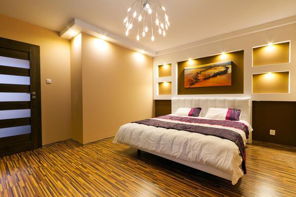 Точечные светильники, расположенные на потолке и стенах, являются органичным украшением спальной комнаты