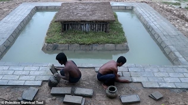 Once the swimming pool has been filled in, the two men lay some more slabs around the outside