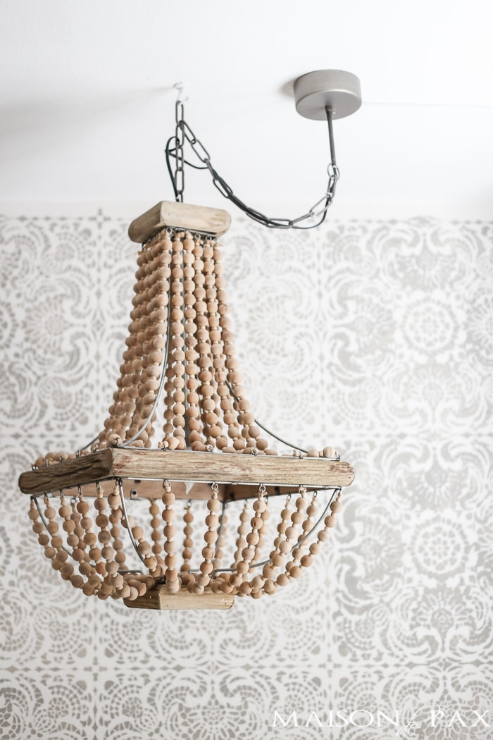 How to hang a plug in chandelier: gorgeous wood bead chandelier in front of a stenciled accent wall